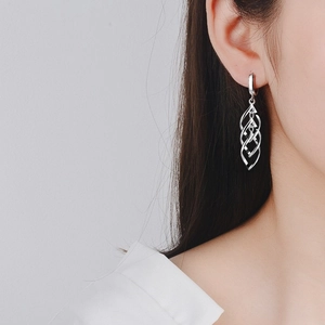 Detailed view of S925 sterling silver twisted drop earrings on a model showing hollow design