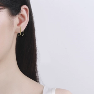 Detail view of a golden minimalist S925 sterling silver hoop and bar earring on a model