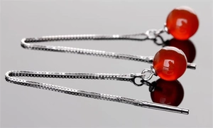 Macro side view of long S925 sterling silver tassel earrings with red agate beads