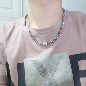 Close-up of a silver Cuban link chain necklace worn on neck for minimalist style