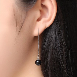 Close-up of S925 sterling silver drop earrings with black onyx bead on a long chain