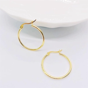 Détail du poinçon S925 sur des boucles d'oreilles créoles classiques plaquées or 18 carats