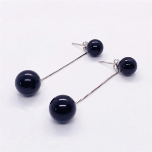 Detail view of S925 silver drop earrings with polished black onyx beads and delicate chains