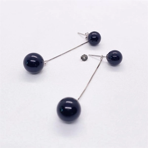 Macro detail of S925 sterling silver stamp and polished black onyx beads on drop earrings