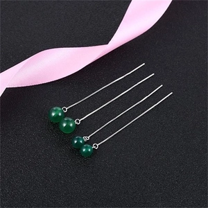 Macro detail of long S925 sterling silver chain earrings with green agate bead charms
