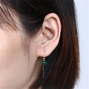 Macro view of long S925 silver threader earrings with a green agate stone on model