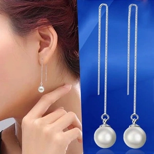 Detailed view of S925 sterling silver long tassel pearl drop earrings on a model