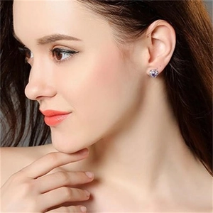 Elegant S925 sterling silver heart-shaped stud earrings with purple crystal on model