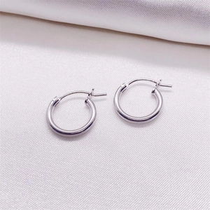 Polished S925 sterling silver hoop earrings on a soft white silk fabric background