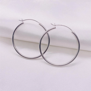 Minimalist S925 sterling silver hoop earrings with a polished mirror finish on white silk