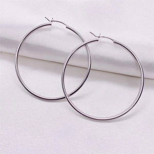 Polished S925 sterling silver large hoop earrings on elegant white silk background