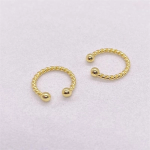 Vue détaillée de boucles d'oreilles torsadées dorées avec deux embouts sphériques