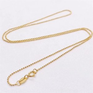 Detailed macro shot of the S925 sterling silver stamp and lobster clasp on a gold ball chain