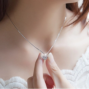 Elegant S925 sterling silver cube pendant necklace worn by a model on a delicate chain