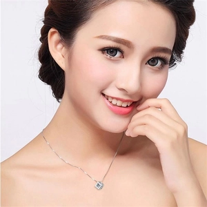 Close-up of a sparkling S925 sterling silver cube pendant necklace on a female model