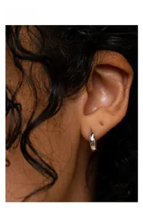 Close-up of a minimalist S925 sterling silver hoop earring shown on a female model's ear