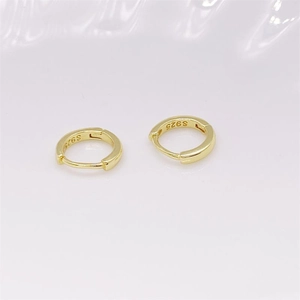 Macro shot of minimalist gold S925 sterling silver hoop earrings with metal hallmark