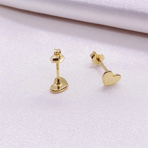 Minimalist S925 sterling silver heart stud earrings with matte gold finish on white silk