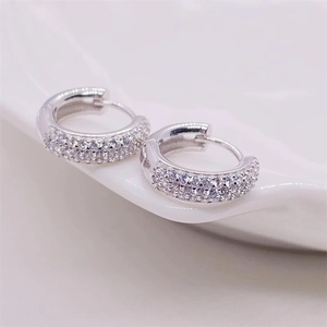 Macro shot of silver S925 sterling silver hoop earrings with triple row zircon stones
