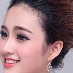 Close-up of S925 sterling silver spinning zircon hook earring worn by a model
