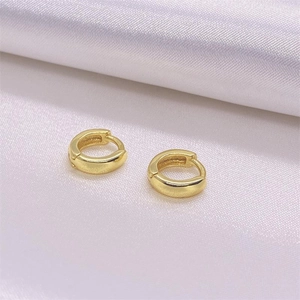 Minimalist pair of S925 sterling silver golden huggie hoop earrings on white silk