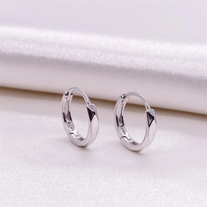 Macro detail of S925 sterling silver hoop earrings with geometric faceted design