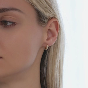 Close-up of gold S925 sterling silver huggie hoop earrings with micro-pave cubic zirconia