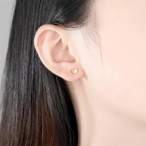 Minimalist S925 sterling silver golden heart stud earrings worn on female model's ear