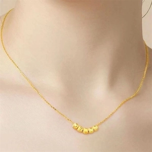 Détail macro du collier en argent S925 avec cinq perles dorées sur la clavicule