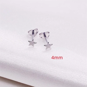Minimalist S925 sterling silver star stud earrings with matte finish on white silk fabric