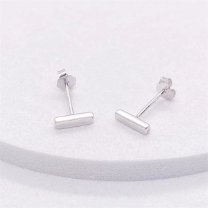 Macro shot of S925 sterling silver bar stud earrings showing the hallmark and polished finish