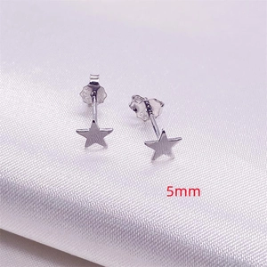 Minimalist S925 sterling silver star stud earrings measuring 5mm on white silk fabric