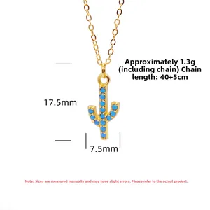 Macro detail of gold cactus pendant featuring turquoise beads and dainty O-chain necklace