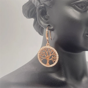 Rose gold tree of life drop earrings with cubic zirconia on a black model head