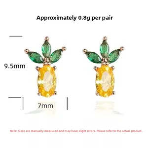 Detail view of S925 silver pineapple stud earrings with yellow and green crystals