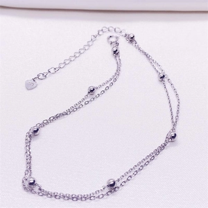 Detail of S925 sterling silver double-layered chain anklet with beads and heart tag