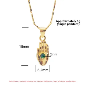 Vue détaillée d'un pendentif main de Hamsa en or avec pierre verte et ses dimensions