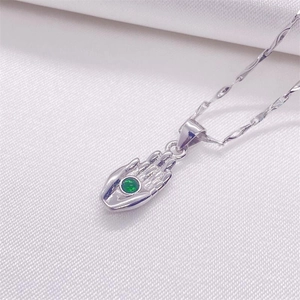 Pendentif main de Hamsa en argent S925 avec pierre verte sur de la soie blanche