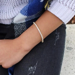 Detail of a sparkling gold tennis bracelet with cubic zirconia on a female wrist