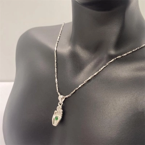 Collier avec pendentif en argent S925 et gemme verte sur un mannequin noir