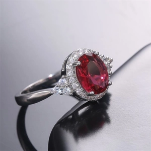 Macro detail of classic S925 silver ring featuring a halo-set red oval zircon stone