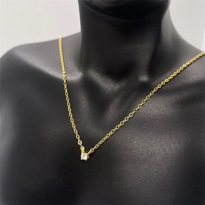 Close-up of minimalist gold S925 silver necklace with single cz pendant on a model