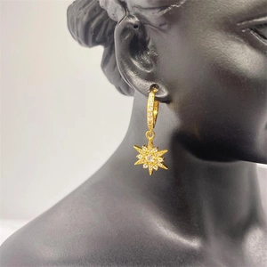 Close-up of gold-plated S925 silver star hoop earrings on a black display model