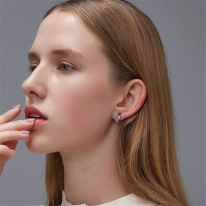 Close-up of a model wearing S925 silver grape earrings with purple and green crystals