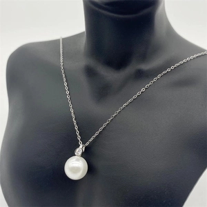 Detailed view of an S925 sterling silver necklace with pearl and sparkling zircon on a model