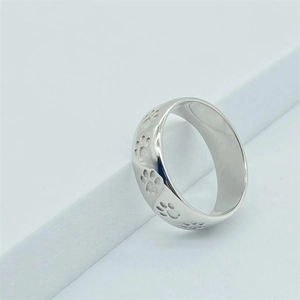 Gros plan d'une bague en argent S925 avec gravure de pattes d'animaux minimalistes