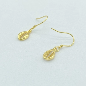 Macro shot of gold-plated S925 sterling silver shell earrings on white surface