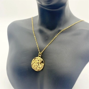 Detailed close-up of a gold mermaid pendant necklace on a black mannequin display