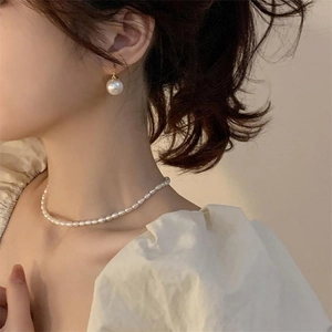 Detail of elegant S925 silver freshwater pearl necklace and earring set on female model