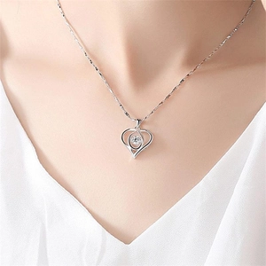 Close-up of S925 sterling silver heart pendant with sparkling crystal on a model's neck